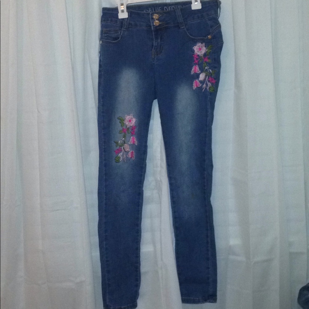 Blue jeans with flower embroidered on the front.